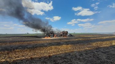 leégett bálázó és traktor