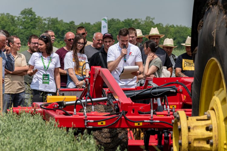 A fotón a NAK Szántóföldi Napok egyik mezőfalvai gépbemutatója látható, ahol a szakmai látogatók egy mezőgazdasági munkagépet figyelnek bemutató közben.